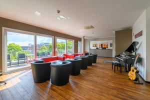 a room with a row of chairs and a piano at Art Rock Downtown Hotel in Cologne