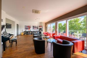 a living room with red furniture and a balcony at Art Rock Downtown Hotel in Cologne
