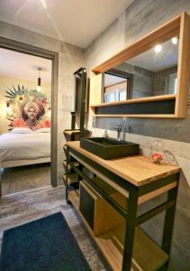een badkamer met een wastafel, een spiegel en een bed bij Domaine Le Sherwood in Notre-Dame-de-Monts