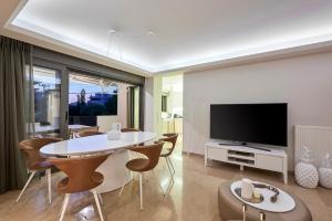 a living room with a table and a tv at Elaia Luxury Apartments Glyfada in Athens