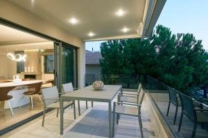 a dining room with a table and chairs and a tree at Elaia Luxury Apartments Glyfada in Athens