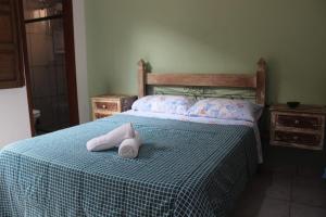 a bedroom with a bed with two towels on it at Casa do Gil in Tiradentes