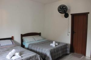 a bedroom with two beds and a fan on the wall at Casa do Gil in Tiradentes +1 photo