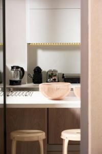 a kitchen with a counter with two stools and a sink at Elaia Luxury Apartments Glyfada in Athens