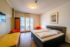 a bedroom with a bed with two chairs and a table at Art Rock Downtown Hotel in Cologne