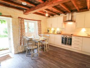 - une cuisine avec une table et des chaises dans la chambre dans l'établissement Kings Cottage, à Grantham