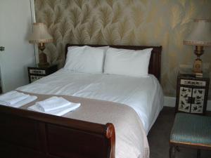 a bedroom with a bed with two lamps and a chair at Bluebells guest house in Barmouth