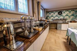 a large kitchen with a counter with a counter at Hotel Eschborner Hof in Frankfurt/Main