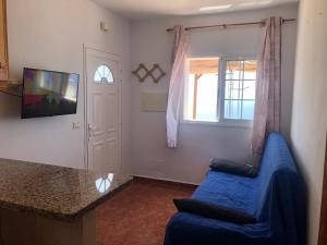 a living room with a blue couch and a window at Casita los vergas in Las Indias