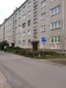 a man walking down a street in front of a building at Atmodas studio in Liepāja