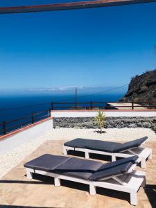 two lounge chairs on a patio with the ocean in the background at Casita los vergas in Las Indias