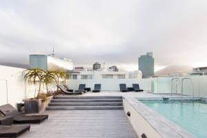 a rooftop deck with a swimming pool on top of a building at Harbour Bridge Waterfront in Cape Town