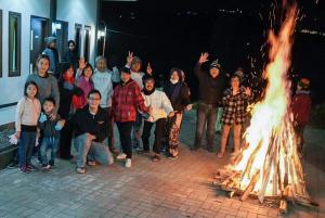 grupa ludzi stojących wokół ognia w obiekcie Bromo Backpacker Tosari w mieście Pasuruan