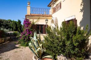 una casa con balcón y algunas plantas y flores en Appartamento Villa Matone, en Grottaferrata