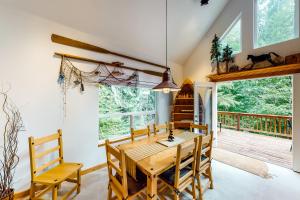 a dining room with a table and chairs and a deck at Alpine Home in Lilliwaup