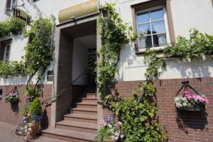 ein Backsteingebäude mit Blumen und Pflanzen darauf in der Unterkunft Hotel Garni Maaß in Braubach