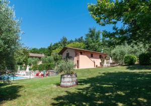 ウンベルティデにあるAgriturismo Il Poggio, Casa Rosaの鉢植えの芝生のある庭の家