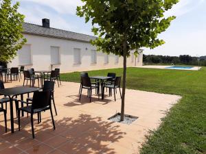 a group of tables and chairs under a tree at Hosteria de Gonzar in Gonzar