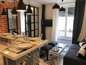 a dining room with a table and a couch at Appartement Hainaut Paris XIXème- Tout Equipé! in Paris