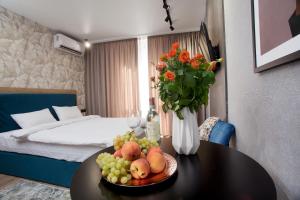 um quarto de hotel com uma mesa com uma taça de fruta em Allurapart Мalahyt em Kiev