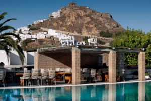 basen z krzesłami i góra w tle w obiekcie Hotel Nefeli w mieście Skiros