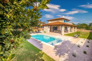 a villa with a swimming pool in front of a house at Villa Aria Istria in Rovinj