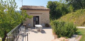 a small building with a table and chairs on a patio at Agriturismo Bosimano in Arcevia