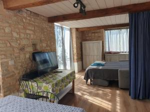 a room with a room with a bed and a tv at Agriturismo Bosimano in Arcevia