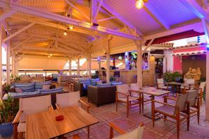 a restaurant with wooden tables and chairs and tablesearcher at Studios Paradise in Kalamaki