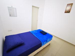 a bed in a room with a blue blanket at SinggahSini Homestay Balok / Gebeng in Kuantan