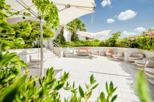 un patio al aire libre con sillas y sombrillas en Berkeley Shore Hotel en Miami Beach