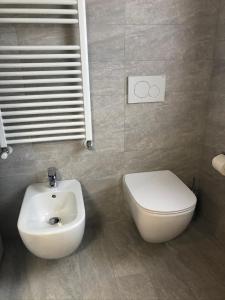 a bathroom with a white toilet and a sink at Monolocale Campo Romano in Schio +13 photos