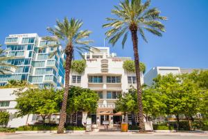 un grupo de palmeras frente a un edificio en Berkeley Shore Hotel en Miami Beach