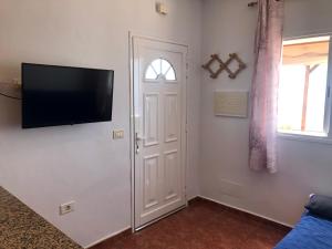 uma sala de estar com uma televisão de ecrã plano na parede em Casita los vergas em Las Indias