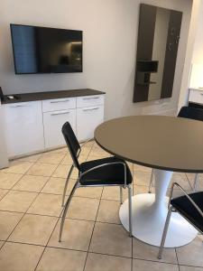 a kitchen with a table and chairs and a tv at Monolocale Campo Romano in Schio