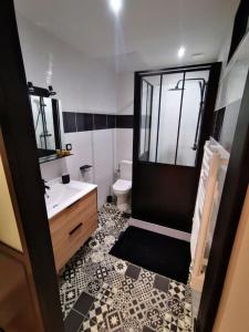 een badkamer met een wastafel, een toilet en een spiegel bij Au numéro 2 Le Zen in Châteauroux