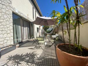 a patio with a table and an umbrella at Bunker 11 Surf House in Charneca