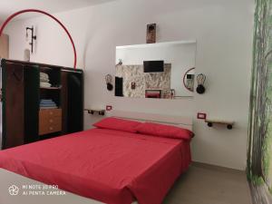 a bedroom with a red bed and a mirror at La Cantina di Giuliano in Falvaterra