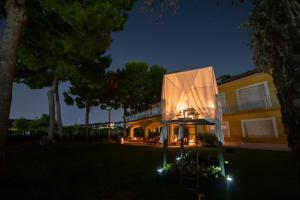 錫羅洛的住宿－Tra gli Alberi e il Mare，夜晚有灯光的外墙的房子