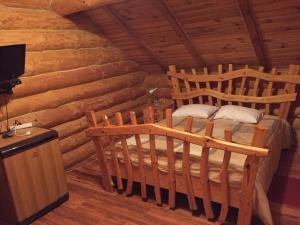 a bedroom with two beds in a log cabin at Villa Carpathian Aura in Skhidnitsa