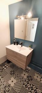 a bathroom with a sink and a mirror at Le Clipper in Saint-Pierre