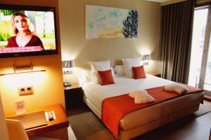 a hotel room with a bed and a flat screen tv at Agua de Mar Hotel Boutique in Vigo