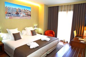 a hotel room with a bed with towels on it at Agua de Mar Hotel Boutique in Vigo