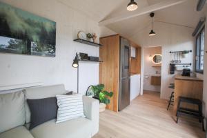 a living room with a white couch and a kitchen at Tiny House - Camping Wagenhausen in Wagenhausen