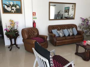sala de estar con muebles de cuero y espejo en Residencia Maria Jose, en Fátima