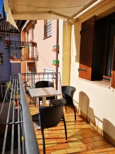 patio ze stołami i krzesłami na balkonie w obiekcie Apartment Goethe 1 w mieście Bolzano