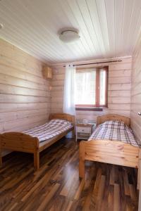 due letti in una stanza con pareti in legno di Kultala Cottage a Korkeakoski