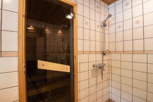 La salle de bains est pourvue d'une douche avec une porte en verre. dans l'établissement Kultala Cottage, à Korkeakoski