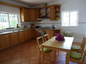 a kitchen with a wooden table and chairs and a table and a table at Villa Olive in Loulé