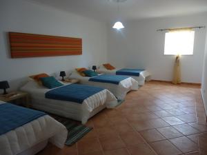 three beds lined up in a room at Villa Olive in Loulé +11 photos